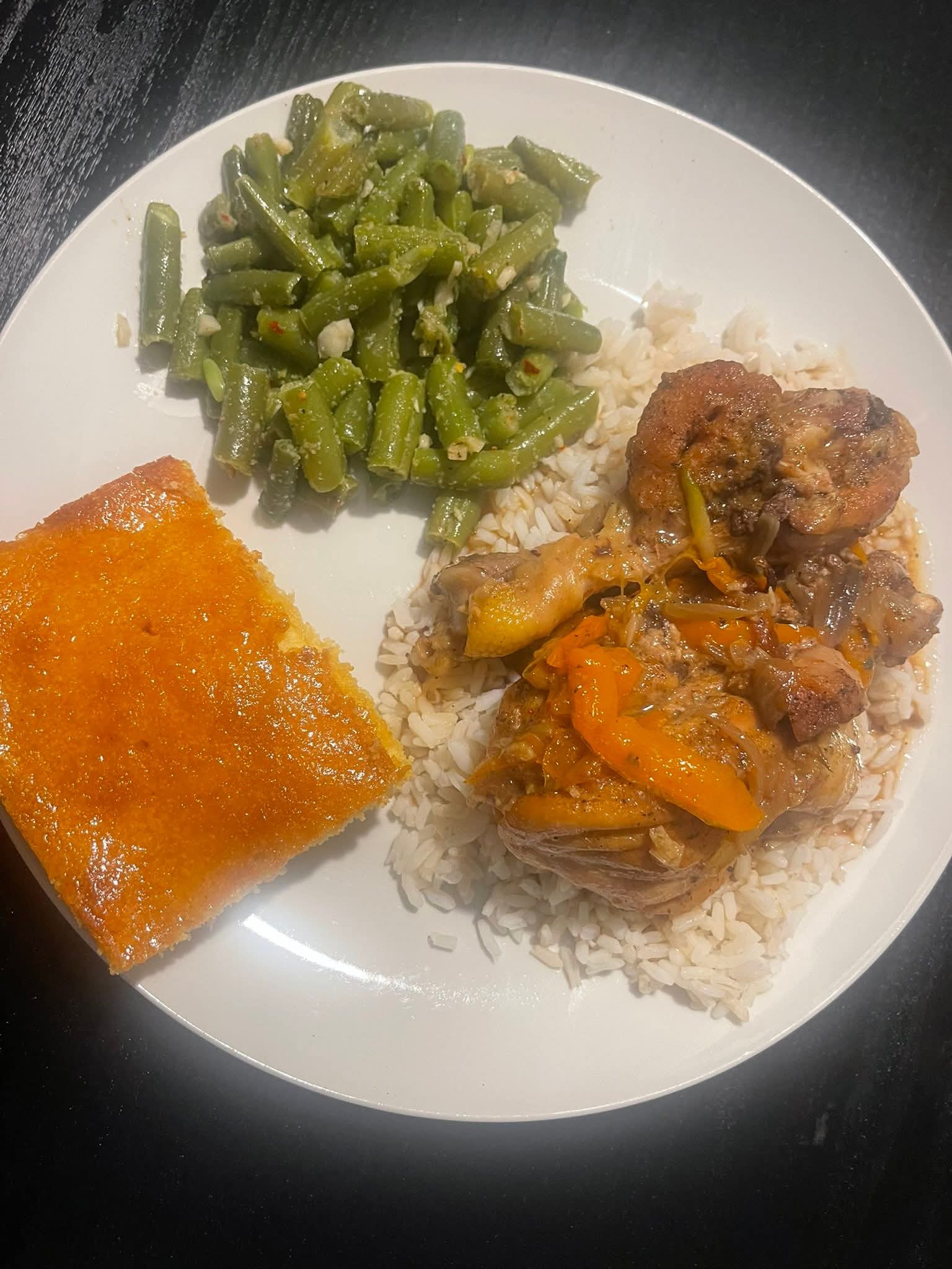 Southern-style plated meal with chicken, rice, green beans, and cornbread